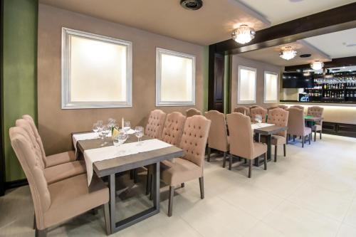 a dining room with tables and chairs and windows at Pietrele lui Solomon in Braşov