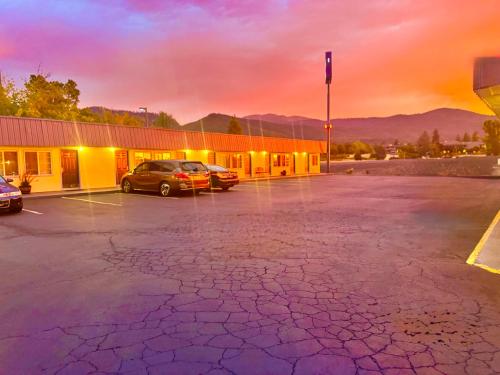 a parking lot with cars parked in front of a building at Relax Inn At Ashland in Ashland