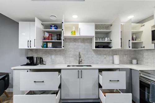 a kitchen with white cabinets and a sink at Blissful Nest - Cozy, Classy 2 Bedroom Private Suite Netflix, free Parking, 20 minutes to West Edmonton Mall and Airport in Edmonton