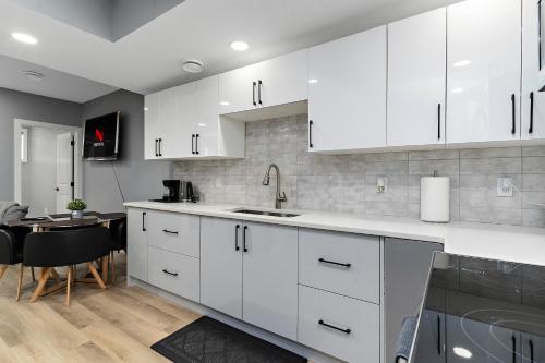 a kitchen with white cabinets and a dining room at Blissful Nest - Cozy, Classy 2 Bedroom Private Suite Netflix, free Parking, 20 minutes to West Edmonton Mall and Airport in Edmonton