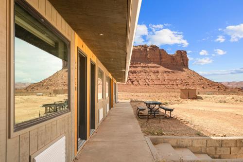 a building with a table and benches in the desert at Marble Canyon Lodge in Marble Canyon