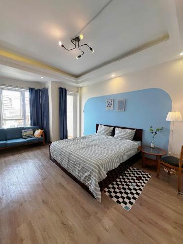 a bedroom with a bed and a blue wall at Anh Truc House - Near Front Beach in Vung Tau