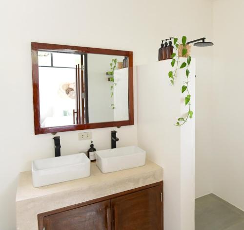 a bathroom with two sinks and a mirror at Villa Pura Vida Apartments Siargao in General Luna