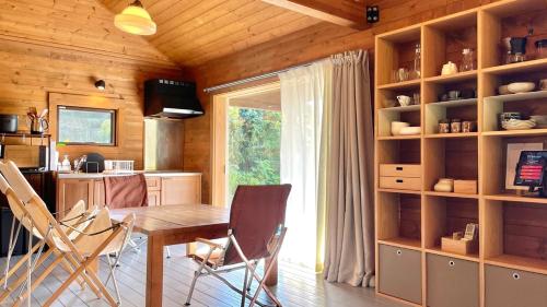 eine Küche und ein Esszimmer mit Tisch und Stühlen in der Unterkunft Log-inn 一棟貸しログハウス in Ama