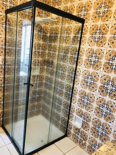 a glass shower in a bathroom with a tiled wall at Hotel Quinta da Bica D'Água in Florianópolis