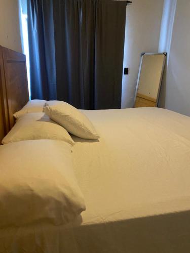 Una cama con sábanas blancas y almohadas en un dormitorio. en Casa Sererno I, en Cuatrociénegas de Carranza