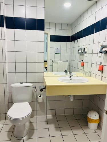 a bathroom with a toilet and a sink at Hotel Le Paris in Noumea