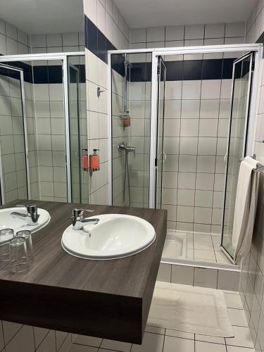a bathroom with two sinks and a shower at Hotel Le Paris in Noumea