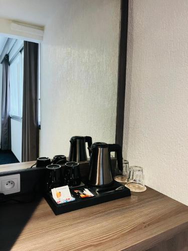 a tray with three coffee pots on a counter at Hotel Le Paris in Noumea