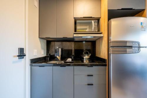 a kitchen with a stainless steel refrigerator and a microwave at Skyline Parque Moinhos by LikeHome in Floresta