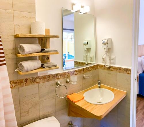 un baño con lavabo y espejo en Posada San Juan, en Cancún