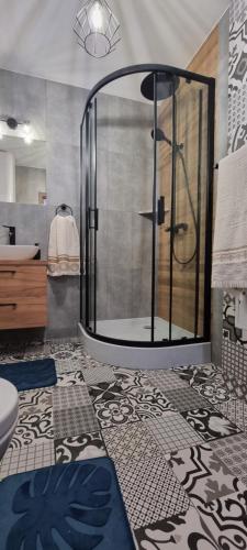 a bathroom with a shower and a sink at Domki pod lasem Gorce z kominkiem i jacuzzi in Ochotnica Dolna