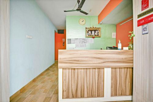 バンガロールにあるHotel O Sri Sai Guru Comfortsのオレンジと緑の壁の受付カウンターのあるオフィス