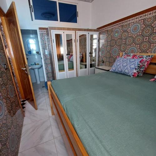 a bedroom with a large bed and a bathroom at 1st floor apartment, sea view in Larache