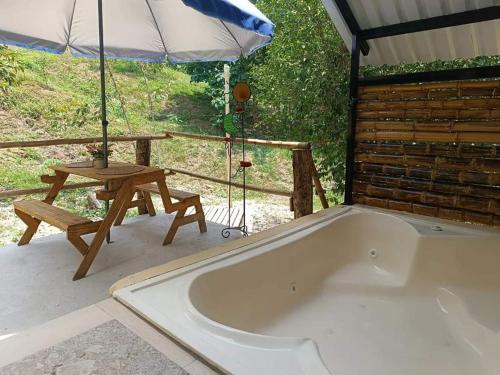 a bath tub with a picnic table and an umbrella at Buena Aventura parejas in Prado