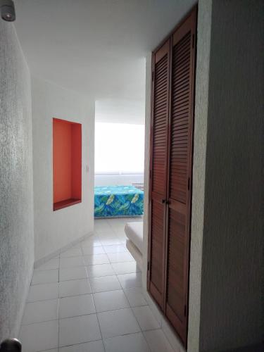 a hallway with a door to a room with a window at Hotel Aristos Acapulco in Acapulco