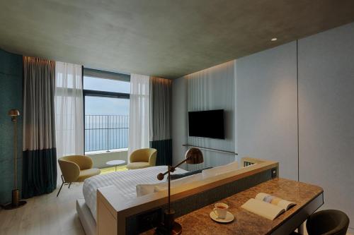 a hotel room with a bed and a television at Sol Beach Namhae in Namhae