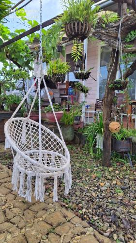a white swinging chair in front of a house at Nông Trại Về Cội - The Original Farm in Buôn Bedeur
