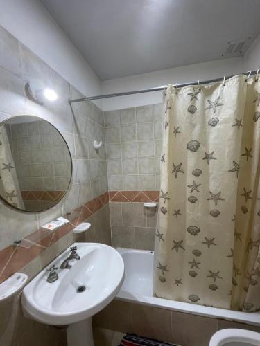 a bathroom with a sink and a shower curtain at Cabaña 32 termas in Chajarí