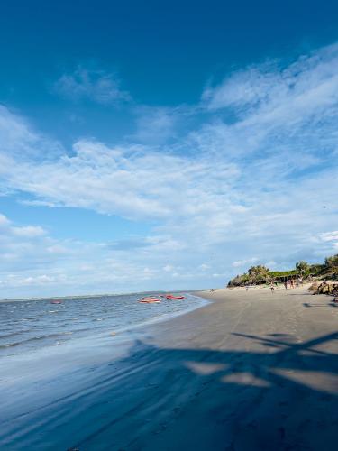a beach with people in the water and the ocean at Casa de Praia Tutóia in Tutóia