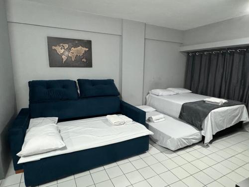 a hotel room with two beds and a couch at No coração do Recife in Recife