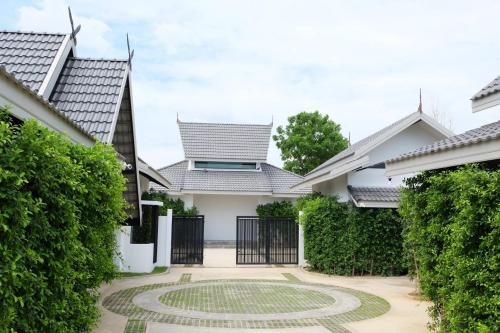 un patio de una casa con jardín en me2 Singhamuntra Resort Kamphaengsaen en Kamphaeng Saen