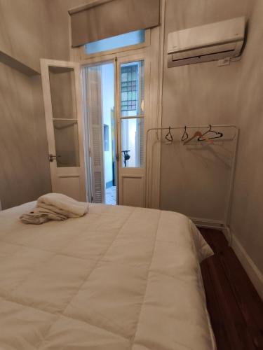 - une chambre avec un grand lit blanc et des lunettes dans l'établissement The Obelisk Corner 3, à Buenos Aires