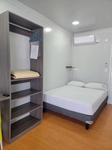 a small bedroom with a bed and a book shelf at Zurban Travelers in Paraíso