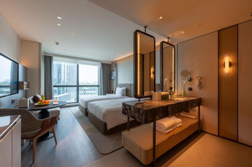 a hotel room with a bed and a desk and a mirror at Holiday Inn Changchun High Tech Zone by IHG in Changchun