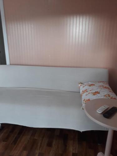 a white bed with a table and a remote control at Cabañas la doña in Aytuy