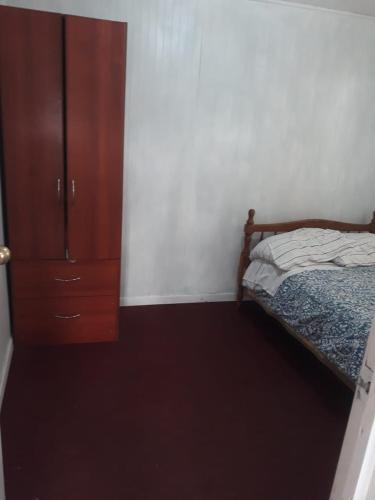 a bedroom with a bed and a wooden cabinet at Cabañas la doña in Aytuy