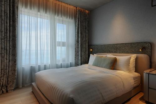 a bedroom with a large bed and a large window at Sol Beach Namhae in Namhae