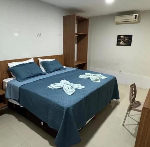 una camera da letto con un letto blu con lenzuola blu e una sedia di Paraíso Pousada, Restaurante e Lazer a João Câmara