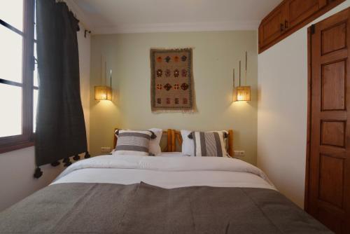 a bedroom with a large bed with two pillows at hostel riad maqam in Essaouira