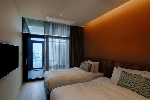a hotel room with two beds and a window at Sol Beach Namhae in Namhae