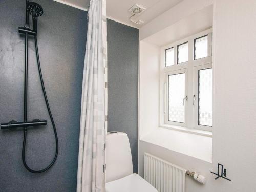 a white bathroom with a shower and a toilet at Romantic 2 person holiday home in Give in Give
