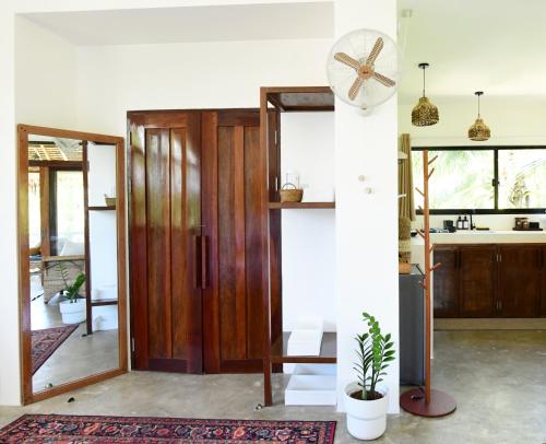 a living room with a wooden door and a fan at Villa Pura Vida Apartments Siargao in General Luna