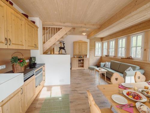 a kitchen and a living room with a table at Chalet near Lake Grundlsee with Sauna in Grundlsee