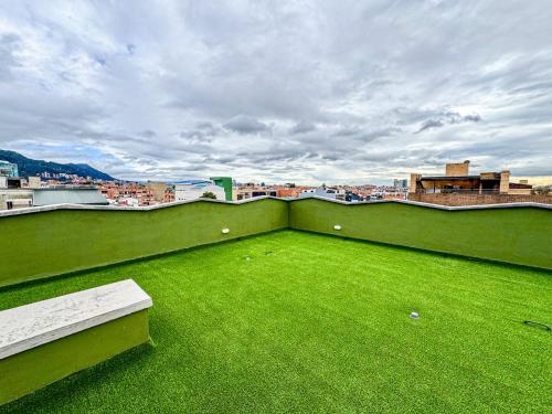 a green balcony with a bench on a roof at Flat 119 in Bogotá