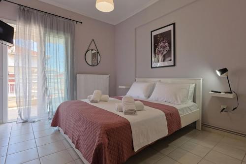 a bedroom with a large bed and a large window at John's Luxury Apartment in Paralia Katerinis