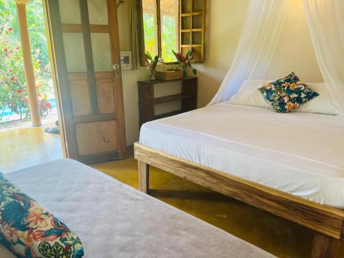 a bedroom with two beds and a door to a yard at Kallpa B&B in Palomino