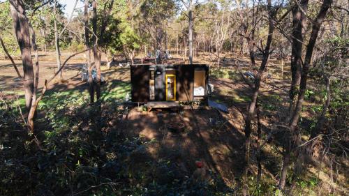 a burnt out vehicle in the middle of a forest at Woodlands by Tiny Away in Howard