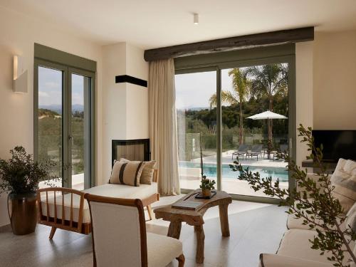 a living room with a view of a pool at Magnificent Crete Villa 4 Bedrooms Villa Ánthos Two Large Private Pools & Jacuzzi Bbq Close To The Beach Rethymno in Prínos