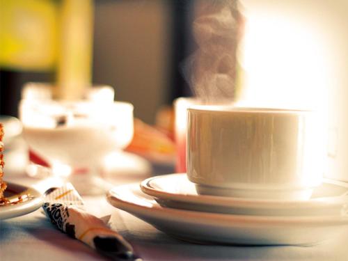 een wit koffiekopje bovenop een tafel bij Pousada do Tesouro in Paraty