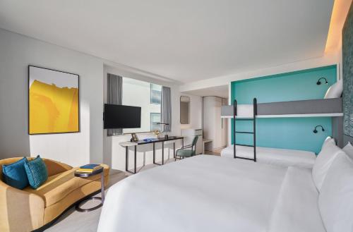 a hotel room with a large bed and a desk at voco Ma Belle Danang by IHG in Da Nang