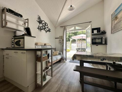 - une cuisine avec un comptoir et une table dans une pièce dans l'établissement Maison rénovée pour 4 pers, proche plage/la mer, WIFI, BBQ, parking, calme près pistes cyclables - FR-1-705-18, à La Palmyre