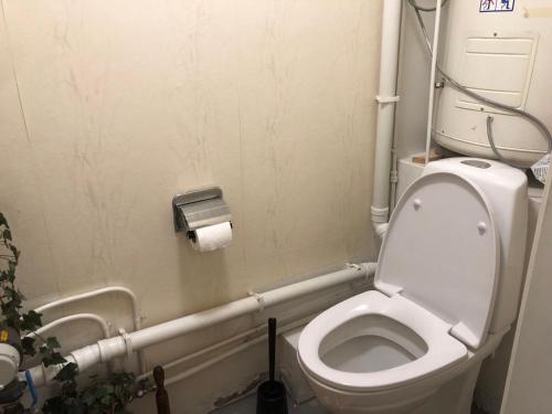 a small bathroom with a toilet with pipes at Billigst i Arendal sentrum uten dusj næringslokaler klinikk og verksted in Arendal