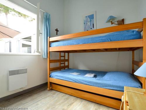 une chambre avec deux lits superposés et une fenêtre dans l'établissement Villa bord de mer 4 pièces, proche plage, animaux admis - FR-1-705-97, aux Mathes