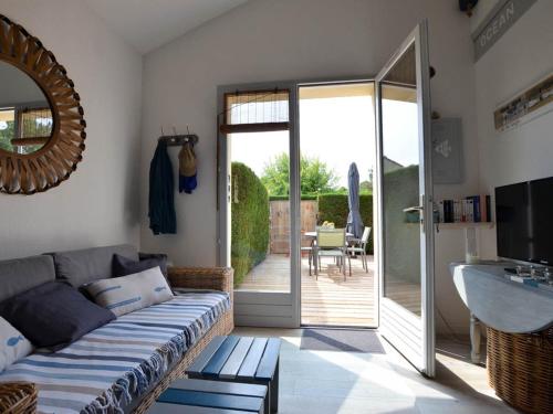 un salon avec un canapé et une porte coulissante en verre dans l'établissement Maison Ravissante 4/5 pers, Jardin Privatif, Parking, Résidence Piscine - FR-1-705-4, à La Palmyre