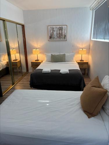 a bedroom with a large bed and two lamps at Tall Timbers Motel in Dungog